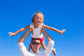 Little girl and dad have fun during tropical beach vacation