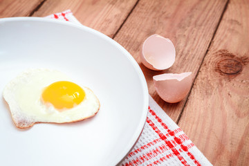 Scrambled eggs on a plate on old wooden table.top view