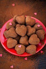 Heart shaped chocolate truffles on red plate