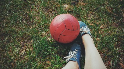 Ball with legs on green grass background