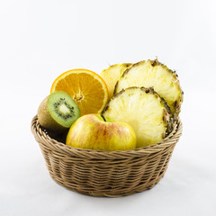 Fruits composition in wicker basket. Cut fruits.