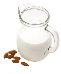 Almond milk in pot on white background
