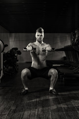 Fototapeta na wymiar Young Man Doing Exercise Dumbbell Squat