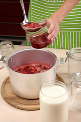 Cooking delicious strawberry jam in kitchen