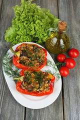 Stuffed red peppers with greens and vegetables on table close