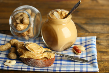 Tasty sandwich and jar with fresh peanut butter