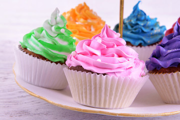 Delicious cupcakes on plate on table close-up