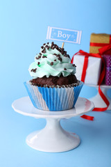 Delicious cupcake with inscription on blue background