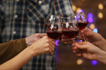 Clinking glasses of red wine in hands