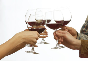 Clinking glasses of red wine in hands isolated on white