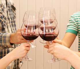 Clinking glasses of red wine in hands