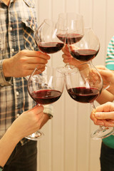 Clinking glasses of red wine in hands