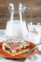 Homemade pie with jam and glass and jug of milk