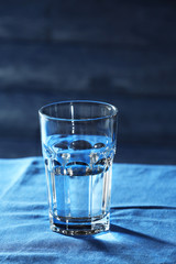 Glass of water on table on wooden background