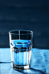 Glass of water on table on wooden background