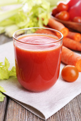 Glass of tomato juice with vegetables on wooden table close up
