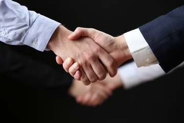 Business handshake on dark background