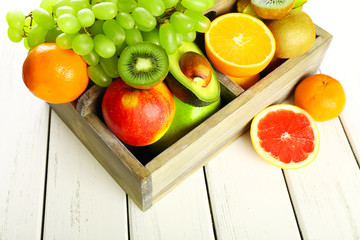 Assortment of fruits in box on wooden table