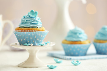 Delicious cupcakes on table on light background