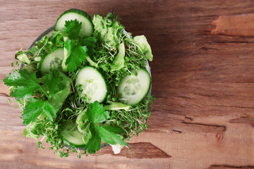 Cress salad with sliced cucumber and parsley in glass bowl