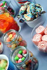 Sweetness in different containers on wooden background