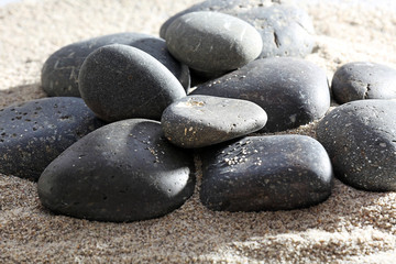 Fototapeta na wymiar Pile of sea pebbles on shiny sand background