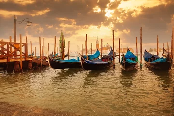 Poster Gondolas at sunset pier near San Marco square in Venice © aragami