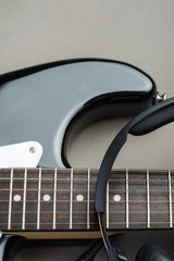 Black guitar frets with strings and headphones