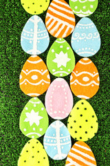 Colorful felt Easter eggs on grass close-up