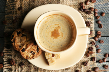 Cup of coffee and tasty cookies on wooden background