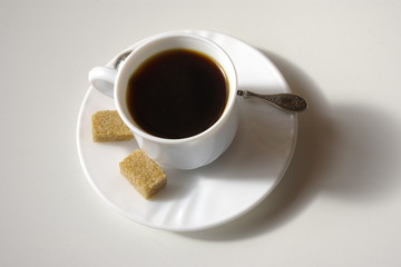 Cup of coffee and cubes brown sugar