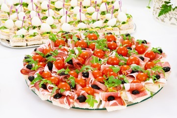 appetizers canapes ham on bread and olives and tomatoes