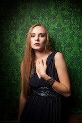 Gorgeous woman on green vintage wall