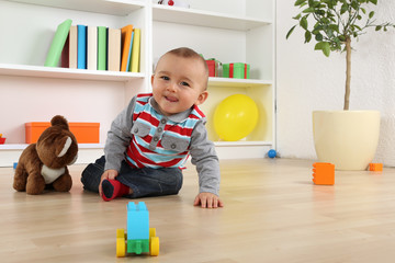 Lachendes Baby Kind beim Spielen mit Spielzeug