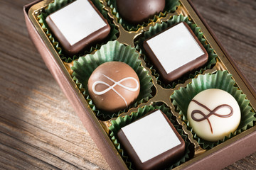 Pralinen in Verpackung auf Holzhintergrund