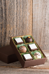 Pralinen in Verpackung auf Holzhintergrund