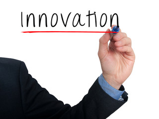 Businessman hand writing innovation in the air. Grey background