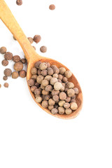 Aromatic allspice in wooden spoon on white background