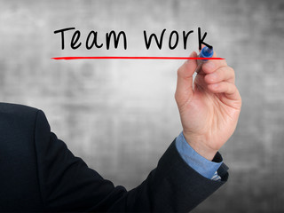 businessman hand writing Team work. Grey background