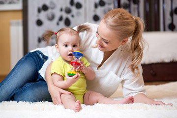 mom and baby playing toy at home