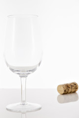 Empty red wine glass and wine bottle cork
