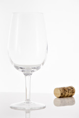 Empty red wine glass and wine bottle cork