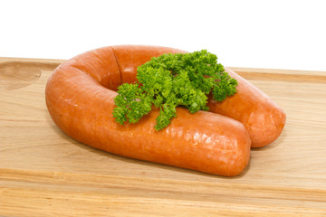 Dutch smoked sausage on a cutting board garnished with curly par