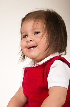 portrait of adorable brunette baby girl wearing red dress
