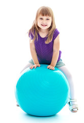 girl doing exercises on the big blue ball.