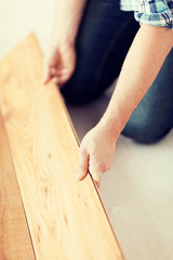 close up of male hands intalling wood flooring