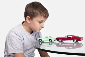 Boy playing with two toy cars
