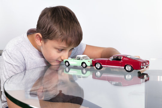Boy playing with two toy cars