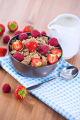Bran flakes with fresh raspberries and strawberries and pitcher
