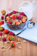 Bran flakes with fresh raspberries and strawberries and pitcher